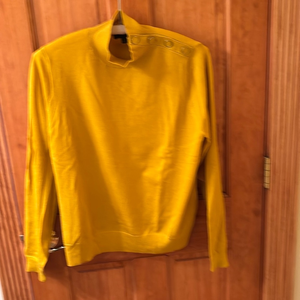 100% merino wool sweater in goldenrod with buttons on the shoulder. Size L.